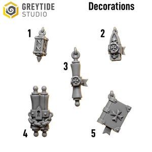 May include: A collection of five gray decorative pendants. The pendants include a lantern, a gothic-style emblem with skulls, a scroll, a double scroll with a chain, and a book with a cross. The word "Decorations" is printed above the pendants.