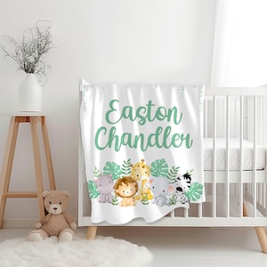 Könnte beinhalten: Weiße Babydecke mit grünem Dschungeltier-Design. Die Decke trägt den Namen Easton Chandler in grüner Kursivschrift.