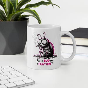 Peut inclure: Un mug en céramique blanche orné d'une illustration graphique représentant un insecte de dessin animé aux grands yeux, fumant une cigarette et tenant une bouteille, entouré de bouteilles vides. Le texte indique "AM I A BUG OR A FEATURE?"