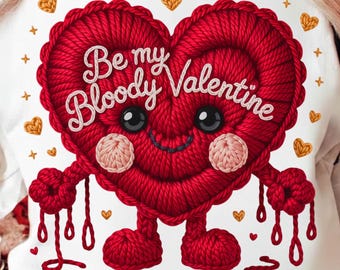 May include: White sweatshirt featuring a red heart-shaped character with the text "Be my Bloody Valentine." The heart has a smiling face, arms, and legs, with gold heart accents. A fun and festive design for Valentine's Day.
