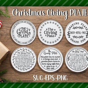 May include: Six white ceramic plates with black text and designs. The plates feature the phrase "The Giving Plate" and various sayings about sharing and giving. The plates are arranged on a wooden surface with a green and white striped background.