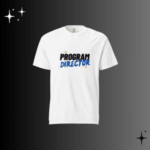 Op de afbeelding: Wit T-shirt met de tekst "PROGRAM DIRECTOR" in zwarte en blauwe letters. De tekst staat in het midden van de voorkant van het shirt. Het shirt heeft korte mouwen en een ronde hals.