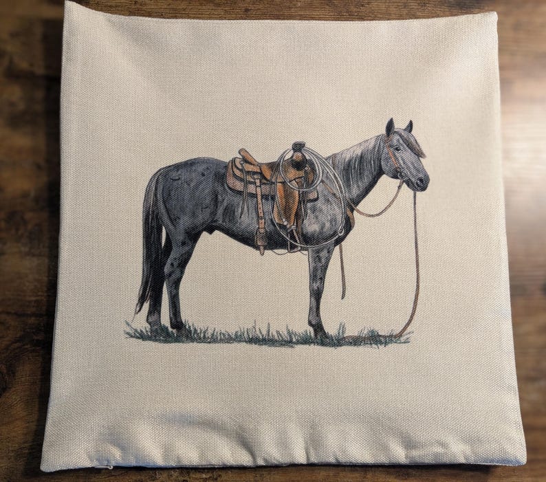 May include: A grey horse with a brown saddle and a rope halter stands on a beige background. The horse is facing the right side of the image.