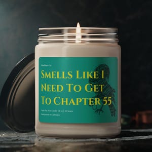 Op de afbeelding: Een brandende sojawas kaars in een glazen pot met een zilveren deksel. Het etiket luidt "Smells Like I Need To Get To Chapter 55" in gele tekst op een turquoise achtergrond, met een vogel illustratie. De kaars is 255g en met de hand gegoten in Californië.