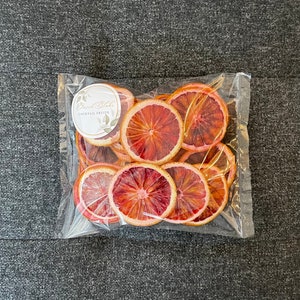 May include: A clear plastic bag filled with dried blood orange slices. The bag has a label that says "David Blake Cocktail Fruits".