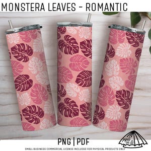 May include: Three stainless steel tumblers with lids and straws. The tumblers feature a repeating pattern of monstera leaves in shades of pink, burgundy, and white on a light pink background. The text "MONSTERA LEAVES - ROMANTIC" is at the top.