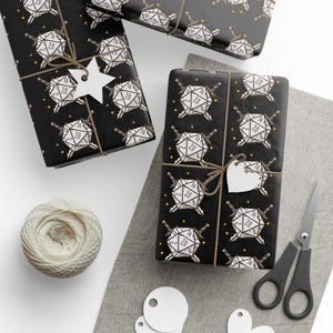 May include: Wrapped gifts with black paper featuring a white d20 dice and sword pattern. Each gift is tied with twine and a blank tag. A ball of twine, scissors, and blank tags are also visible.