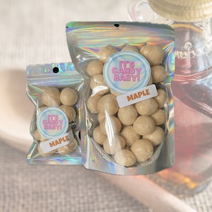 May include: Two bags of maple flavored candy. The bags are iridescent and have a label that says "It's Candy Baby!" and "Maple".