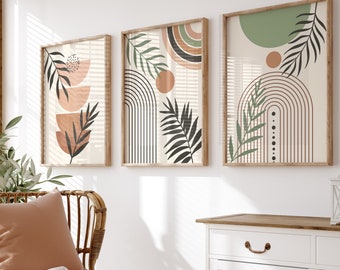 Puede incluir: Tres impresiones artísticas abstractas enmarcadas con diseños botánicos y geométricos. Las impresiones presentan colores tierra, incluyendo beige, marrón y verde, con detalles de hojas y líneas negras. La obra de arte se exhibe sobre un mueble blanco y una silla de mimbre.