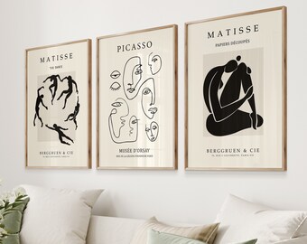 May include: Three black and white minimalist art prints with the names Matisse, Picasso, and Matisse in white text. The Matisse prints feature a black silhouette of dancers and a woman sitting with her legs crossed. The Picasso print features a series of black line drawings of faces.
