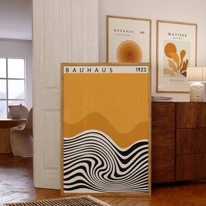 K&ouml;nnte beinhalten: Ein Bauhaus-Plakat mit gelbem Hintergrund und schwarzen und wei&szlig;en wellenf&ouml;rmigen Linien. Das Plakat tr&auml;gt den Text "BAUHAUS 1923" oben.