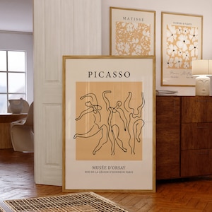K&ouml;nnte beinhalten: Ein minimalistischer Kunstdruck mit einer Linienzeichnung von T&auml;nzern in Schwarz auf einem Pfirsichhintergrund. Der Druck tr&auml;gt den Text "PICASSO" oben und "MUS&Eacute;E D'ORSAY" unten sowie die Adresse "RUE DE LA L&Eacute;GION D'HONNEUR PARIS".