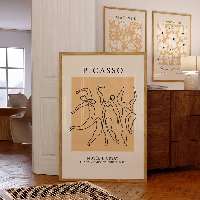 K&ouml;nnte beinhalten: Ein minimalistischer Kunstdruck mit einer Linienzeichnung von T&auml;nzern in Schwarz auf einem Pfirsichhintergrund. Der Druck tr&auml;gt den Text "PICASSO" oben und "MUS&Eacute;E D'ORSAY" unten sowie die Adresse "RUE DE LA L&Eacute;GION D'HONNEUR PARIS".