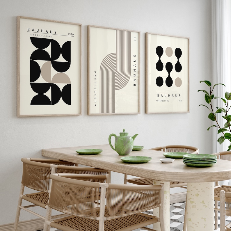 May include: Three framed prints with geometric shapes in black, white, and beige. The prints have the text "Bauhaus Ausstellung 1919" on them.