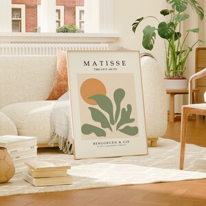 May include: A beige poster with a green abstract design and a yellow circle. The poster has the text "MATISSE THE CUT-OUTS" and "BERGGRUEN & CIE 70, RUE DE L'UNIVERSITE, PARIS-VII".