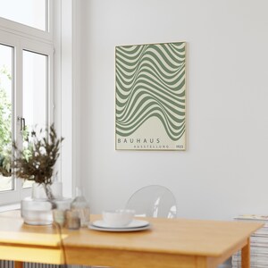 May include: A green and white abstract art print with a gold frame. The print features a series of wavy lines and the text "BAUHAUS AUSSTELLUNG 1923".