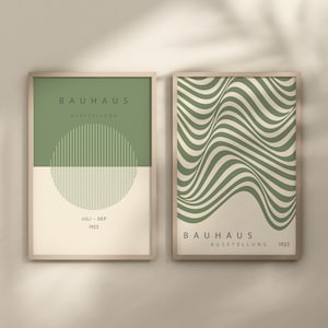 May include: Two framed prints with a green and white geometric design. The left print has the text "BAUHHAUS AUSSTELLUNG JULI - SEP 1923" and a circle with vertical lines. The right print has the text "BAUHHAUS AUSSTELLUNG 1923".