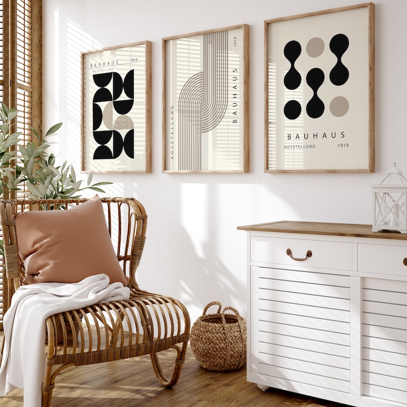 May include: Three framed prints with geometric shapes and the text "BAUHAUS AUSSTELLUNG 1919" in black and white on a beige background.