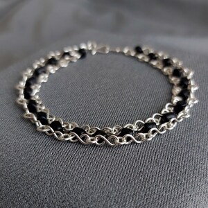 The geometric silver plated wire bracelet with black beads.