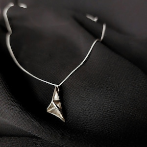 Sterling silver triangular pendant on a chain.