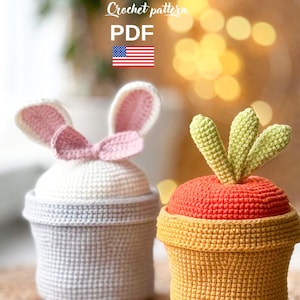 May include: Two crochet storage containers: one shaped like a bunny with pink ears and a bow, the other like a carrot with green leaves. The containers are in light blue, white, orange, and yellow. Text on the image reads "Crochet pattern PDF".
