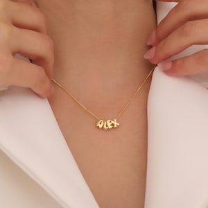 Könnte beinhalten: Goldkette mit dem Namen "ALEX", der in einzelnen Buchstaben geschrieben ist.