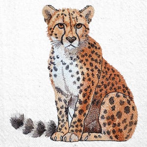 Op de afbeelding: Geborduurd cheetah-ontwerp in tinten bruin, beige en zwart. De cheetah wordt zittend afgebeeld, met zijn staart opgerold. De borduursels tonen gedetailleerde steken, waardoor een textuur ontstaat. De achtergrond is een effen witte stof.