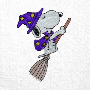 May include: Embroidered image of Snoopy, the Peanuts character, dressed as a wizard. Snoopy wears a purple hat and cape with yellow stars, riding a brown broomstick. The image is set against a white background.