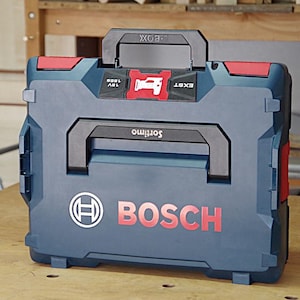 May include: A dark blue Bosch L-Boxx tool case with red accents, a black handle, and the text Sortimo and 18V 180B printed on the top. The front features the white Bosch logo and the word BOSCH in large red letters on a durable plastic shell.