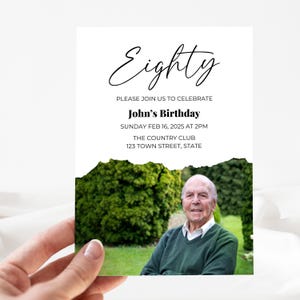 May include: A white invitation card with a black handwritten font that says "Eighty". The invitation is for John's birthday, which is on Sunday, February 16, 2025 at 2 PM. The invitation is for a party at The Country Club, located at 123 Town Street, State. The bottom of the invitation is torn to reveal a photo of a man in a green shirt.