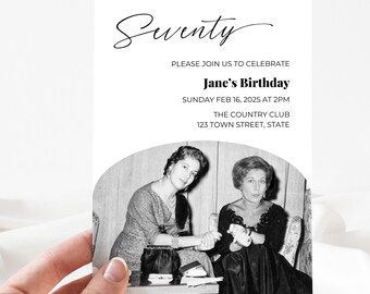 Op de afbeelding: Een witte uitnodigingskaart, vastgehouden door een hand, met het woord "Seventy" in sierlijke letters. De kaart nodigt gasten uit voor Jane's verjaardag op 16 februari 2025 om 14.00 uur in The Country Club. Zwart-wit foto.