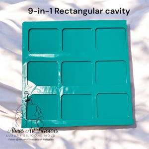 Puede incluir: Un molde de silicona de cavidad rectangular 9 en 1 de color verde azulado. El molde tiene nueve cavidades cuadradas. El texto "9-in-1 Rectangular cavity" está en la parte superior. El texto "Almas Art Treasures LUXURY SILICONE MOLD" está en la parte inferior.