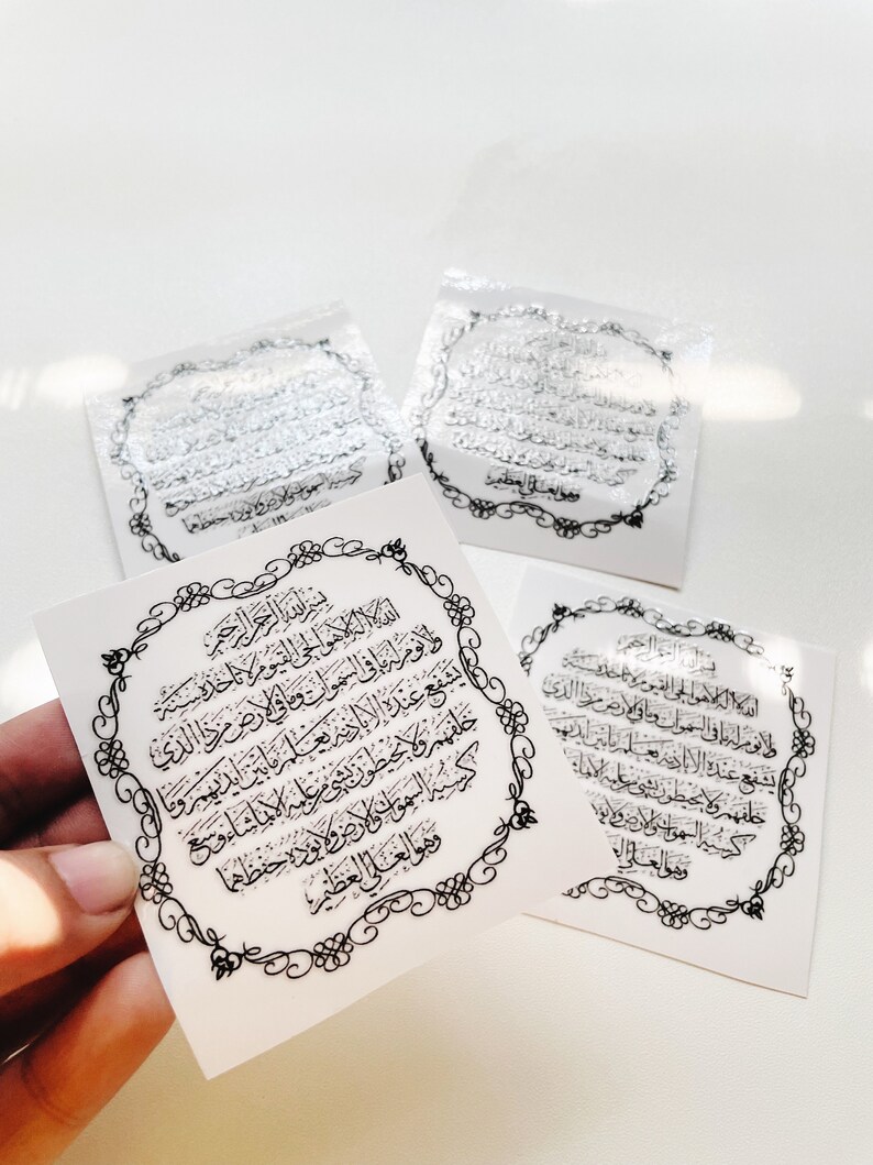 Może przedstawiać: Cztery białe kwadratowe naklejki z czarnymi ozdobnymi ramkami i arabską kaligrafią w środku. Tekst brzmi "Bismillah ir-Rahman ir-Rahim" i "Allah hu Allah la ilaha illa hu al-Hayyu al-Qayyum"