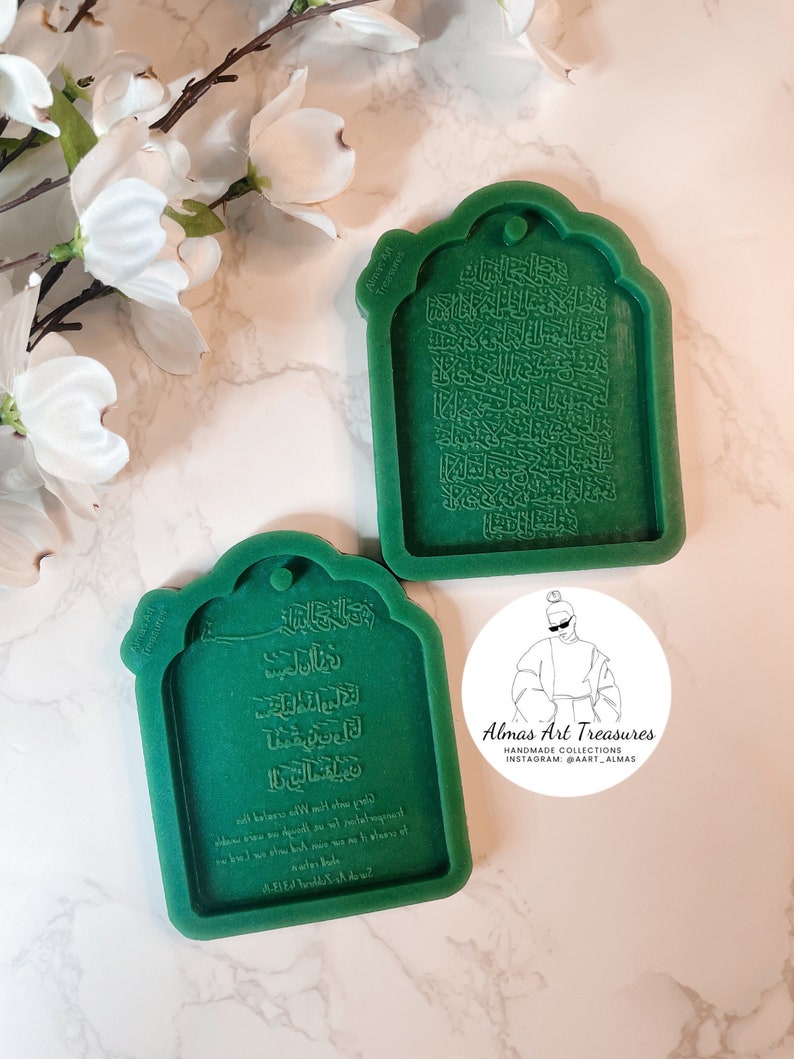 May include: Two green silicone molds for making resin crafts. The molds are shaped like a traditional Islamic archway and feature Arabic calligraphy. The text in the molds reads "Almas Art Treasures Handmade Collections Instagram: @aart_almas".