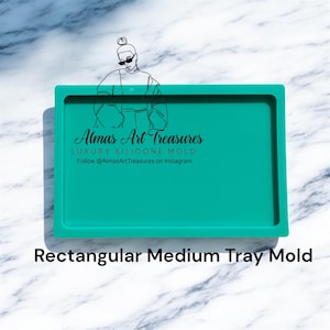 Puede incluir: Un molde de bandeja rectangular de silicona turquesa de tamaño mediano. El molde tiene un borde elevado y está diseñado para manualidades. El texto "Almas Art Treasures" y "Rectangular Medium Tray Mold" son visibles. El fondo es un patrón de mármol.