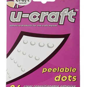 Op de afbeelding: Een roze verpakking met de tekst "u-craft" en "peelable dots" in geel. De verpakking bevat 96 transparante, repositioneerbare lijm stippen op gemakkelijk te gebruiken vellen. De verpakking is zuurvrij en ligninevrij.