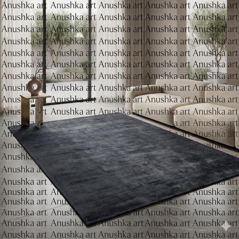 May include: A large, rectangular charcoal-colored rug. The rug has a soft, textured appearance and is placed on a light-colored floor. The rug is a neutral color and would complement various interior design styles.