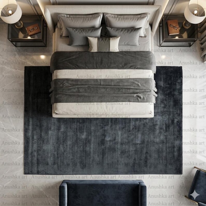 May include: An overhead view of a bedroom setup featuring a bed with gray and white bedding, surrounded by matching pillows. A dark gray rug is placed at the foot of the bed. Two nightstands with lamps flank the bed, creating a modern and elegant aesthetic.