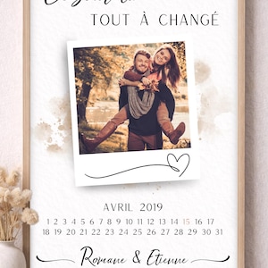 Peut inclure: Impression encadrée avec une photo d'un couple, un calendrier d'avril 2019 et le texte "Ce jour là TOUT À CHANGÉ". Les noms "Romane & Etienne" et la date "15 AVRIL 2019" sont également affichés. Le cadre est de couleur marron clair.
