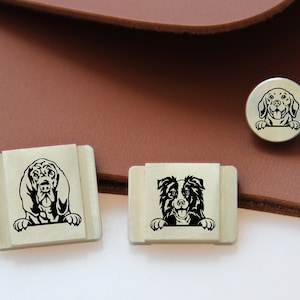 May include: Three silver metal dog tag charms with black and white illustrations of dogs. The charms feature a Bloodhound, a Border Collie, and a Golden Retriever.