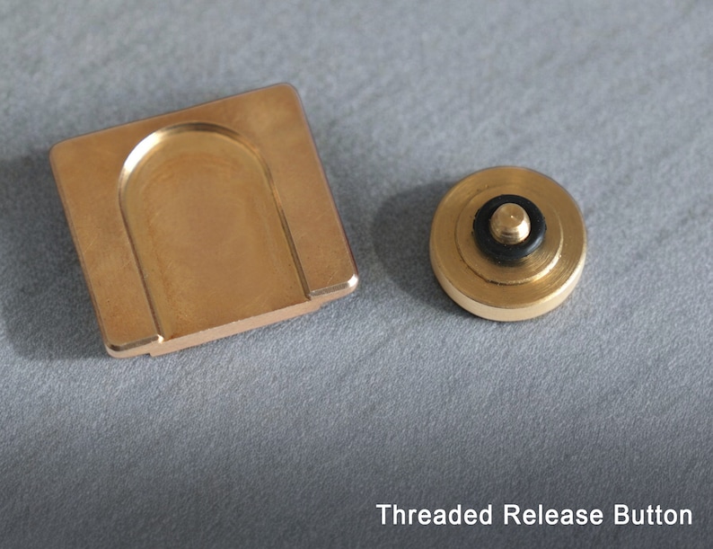 May include: A gold-colored threaded release button for a fidget spinner. The button has a black rubber ring around the top.