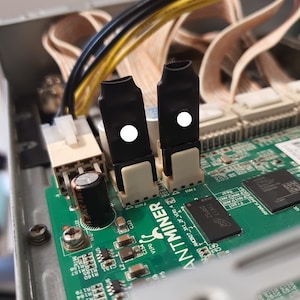 Könnte beinhalten: Nahaufnahme einer Platine mit zwei schwarzen Steckverbindern und dem aufgedruckten Text "ANTMINER".