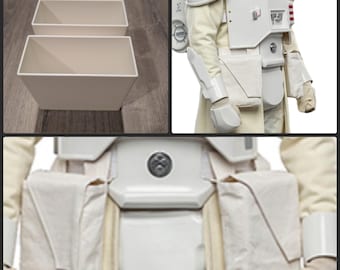 May include: Two white, square-shaped containers with a minimalist design. The image also shows a detailed view of a white costume with pouches and armor, featuring a chest plate and belt with a circular emblem.