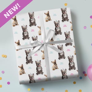 May include: White wrapping paper with a repeating pattern of French Bulldogs in party hats and bow ties, with "Happy Birthday!" text. A white ribbon is tied around the gift. A purple banner in the corner reads "NEW!"