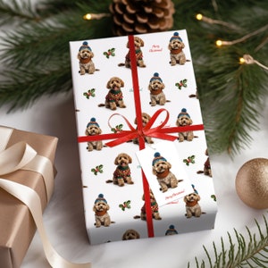 May include: White wrapping paper with a repeating pattern of brown dogs wearing Santa hats and red sweaters. The dogs are holding holly sprigs and the text "Merry Christmas!" is printed on the paper.