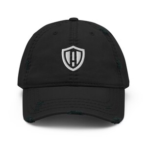 May include: Black distressed baseball cap with a white embroidered shield logo featuring the letter "A" inside.