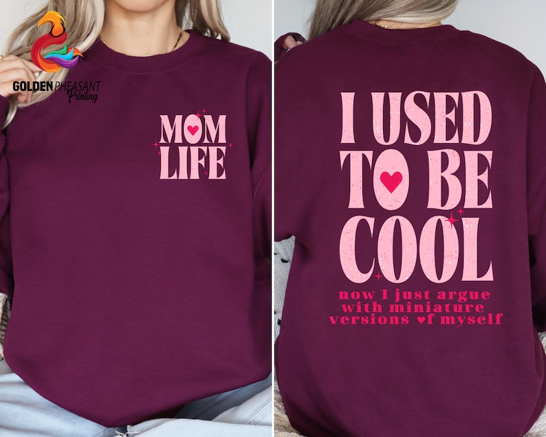 May include: Burgundy sweatshirt with pink text that reads "MOM LIFE" on the front and "I USED TO BE COOL now I just argue with miniature versions of myself" on the back.