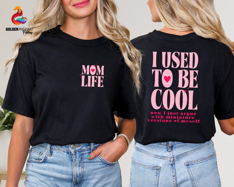 May include: Black t-shirt with pink text that reads "MOM LIFE" on the front and "I USED TO BE COOL now I just argue with miniature versions of myself" on the back.