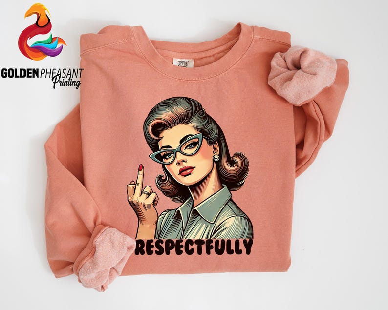 May include: A coral-colored sweatshirt featuring a retro-style illustration of a woman wearing glasses and giving the middle finger. The word "RESPECTFULLY" is printed in red below the image. The Golden Pheasant Printing logo is in the upper left corner.