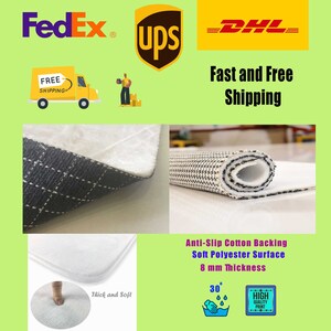 May include: A white bath mat with a black and white checkered pattern on the back. The mat is 8 mm thick and has a soft polyester surface. It is machine washable at 30 degrees Celsius. The mat is made with an anti-slip cotton backing.
